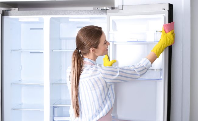 Woman,In,Rubber,Gloves,Cleaning,Refrigerator,At,Home